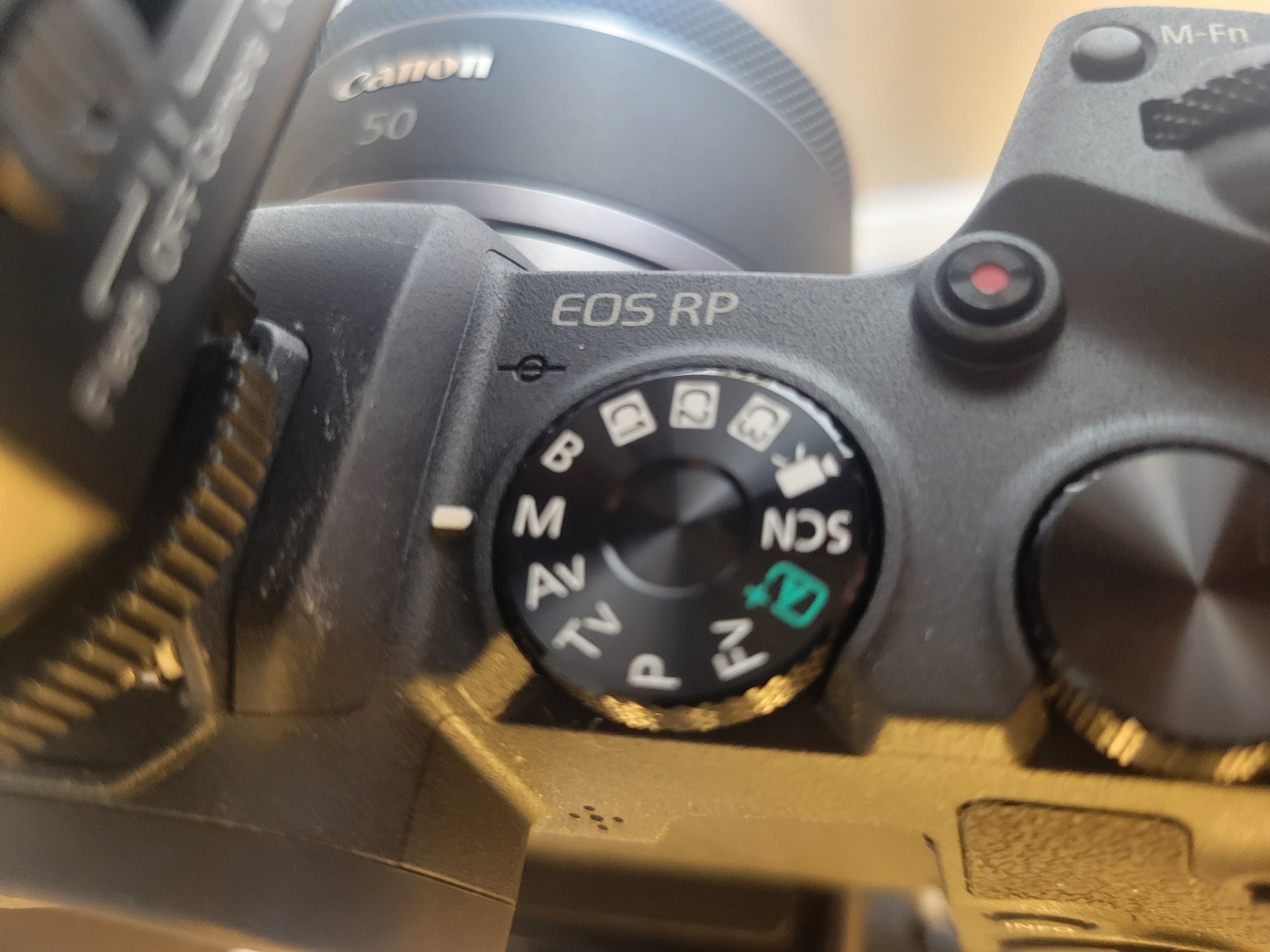 slightly blurred photo of the top of a digital SLR camera mode selection wheel turned so that the indicator line is next to the 'M'